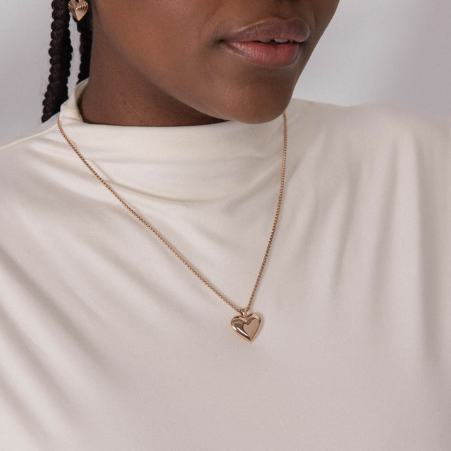 Roségoldene Herz-Halskette von PURELEI, elegant und feminin, getragen auf einem weißen Oberteil.