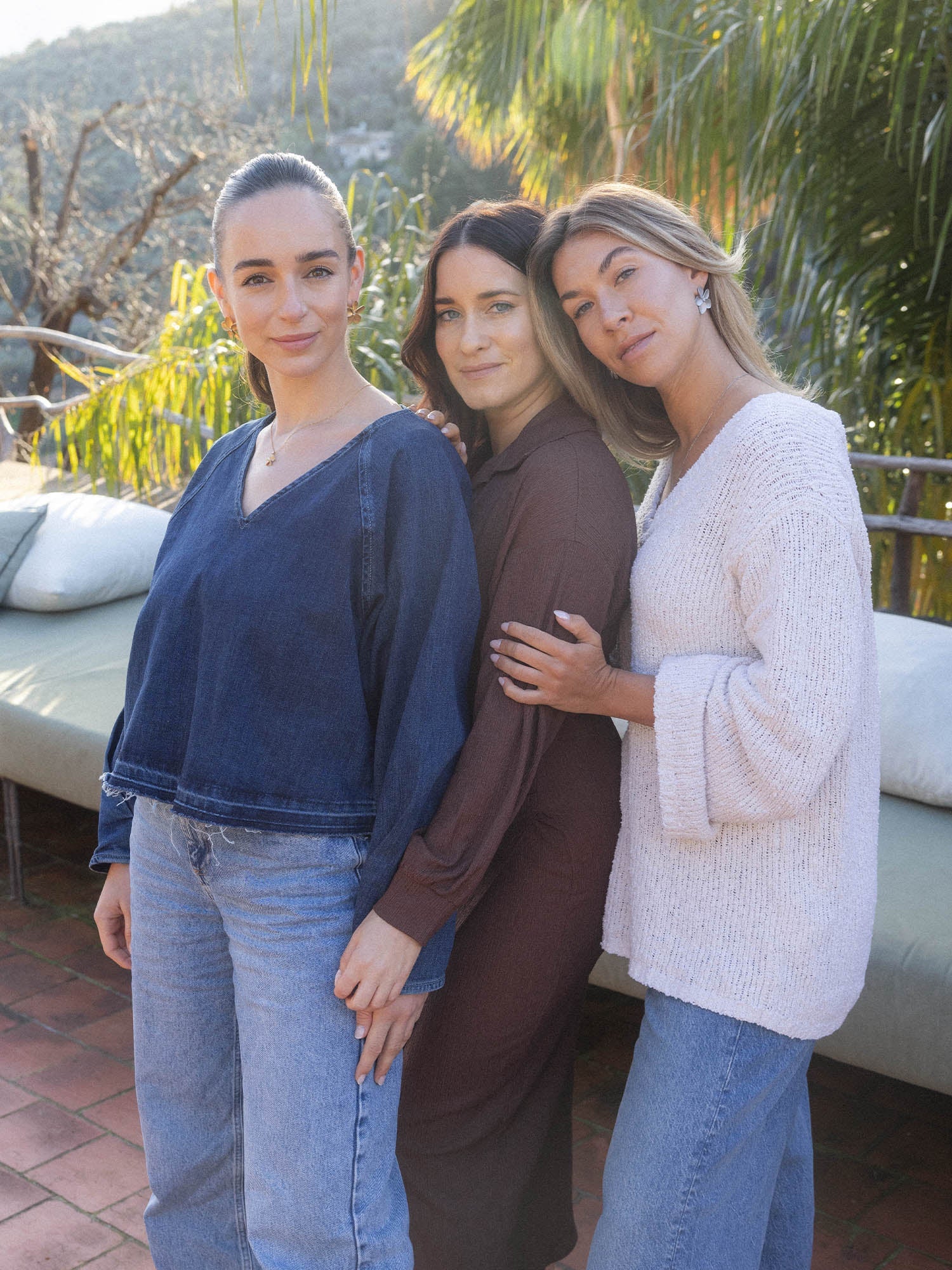 PURELEI Empowerment Ohrringe in gold mit filigraner Blütenform, getragen in natürlicher Outdoor-Umgebung