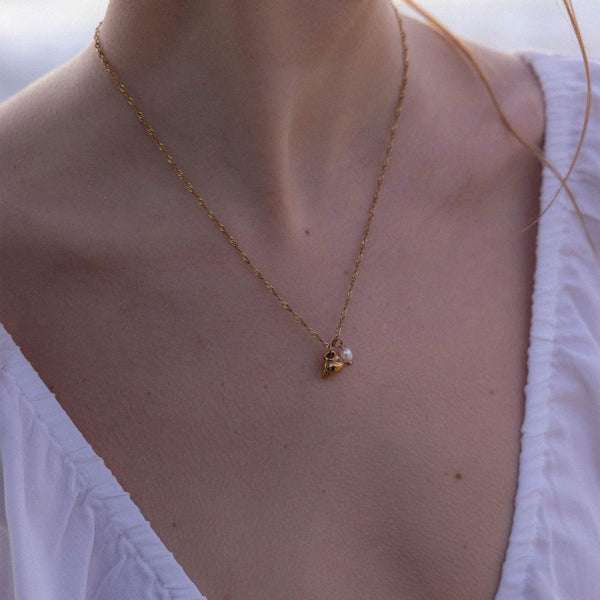 Roségoldene Kette mit Muschel- und Perlenanhänger, getragen mit eleganter Ausstrahlung – PURELEI.