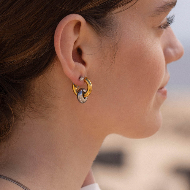 Silberne Creolen mit Wellenstruktur, getragen von einer Frau, PURELEI inspiriert.