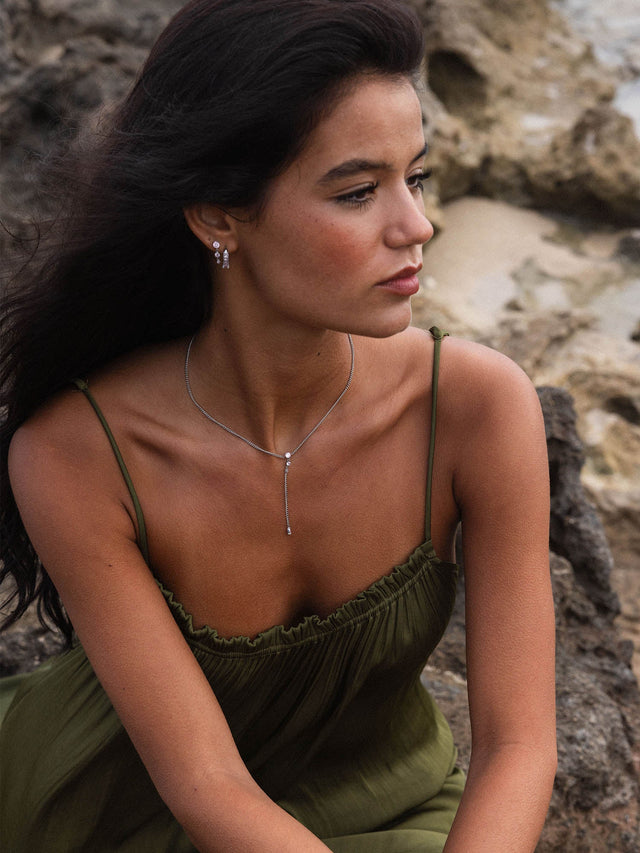 Silberne Kette und Ohrringe von PURELEI, elegant und feminin, getragen in natürlicher Umgebung.