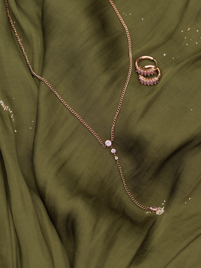 Zarte Kette und Ring aus Roségold auf grünem Stoff, PURELEI inspiriert.