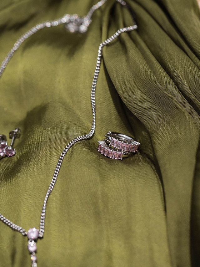 Silberne Kette und Ring auf grünem Stoff, elegant und zeitlos, von PURELEI.