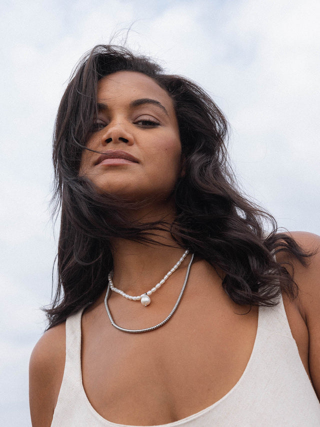 Zarte PURELEI Ketten aus Silber und Perlen, getragen in natürlicher Umgebung.