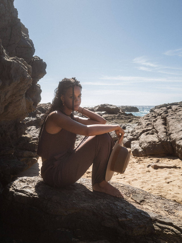 Tiger's Eye Charm Kette mit goldbraunen Tigerelementen, warm schimmernd, PURELEI, am Strand getragen, elegant und naturverbunden.