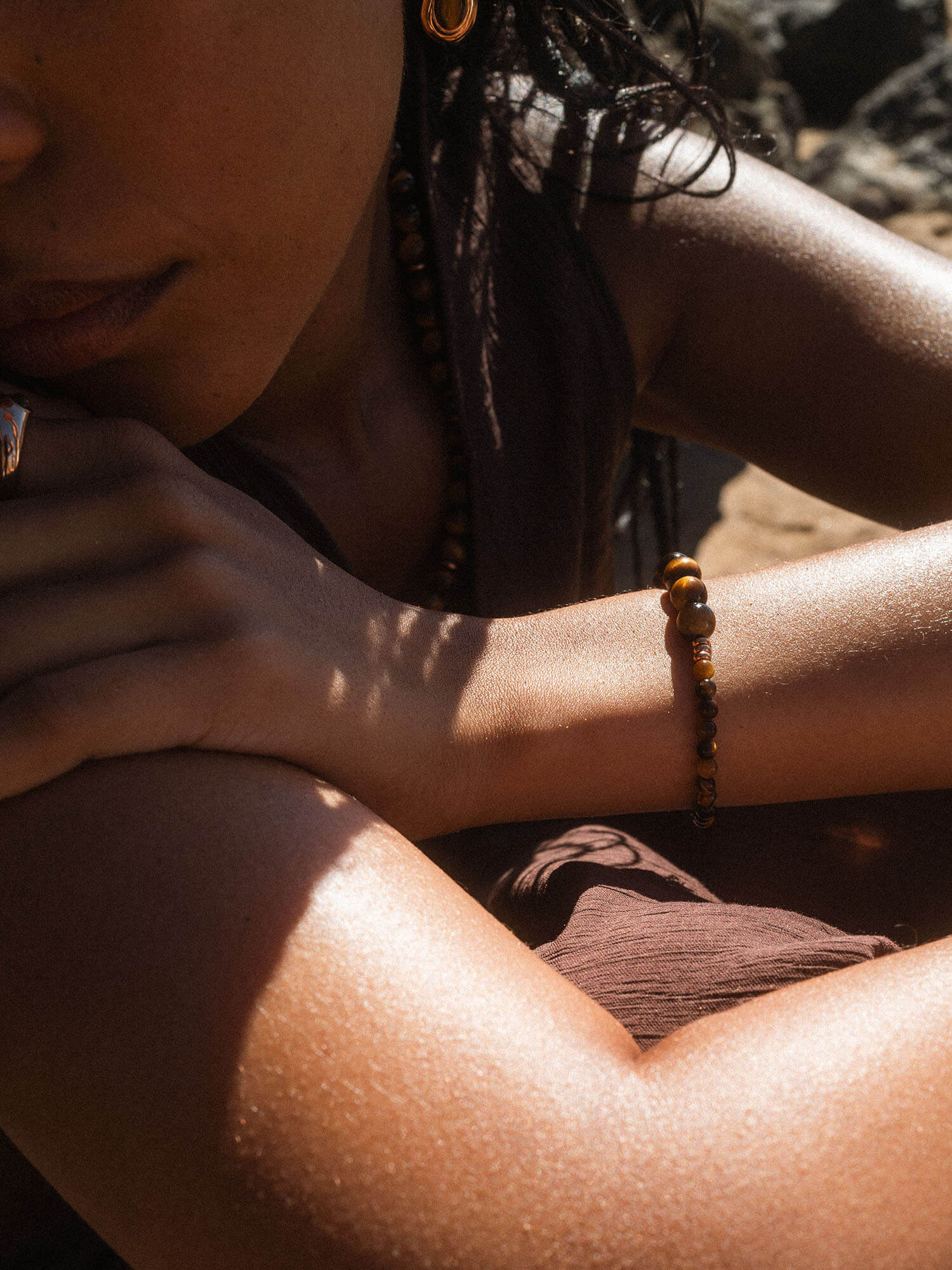 Braunes Armband aus Holzperlen, getragen in warmem Licht, von PURELEI.