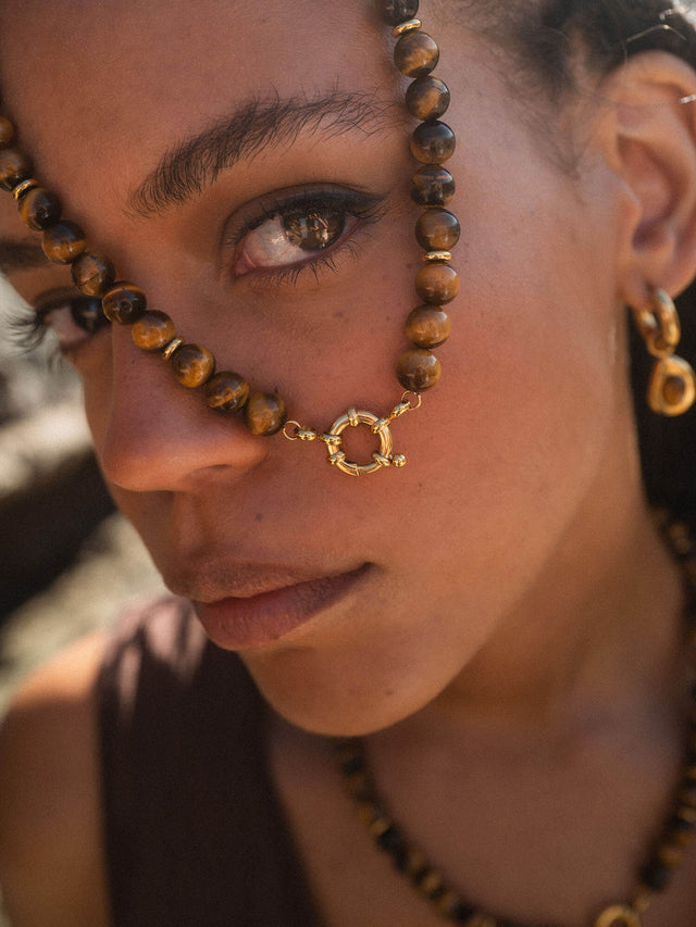 Braune Holzperlenkette mit silbernem Anhänger, getragen mit natürlicher Eleganz von PURELEI.