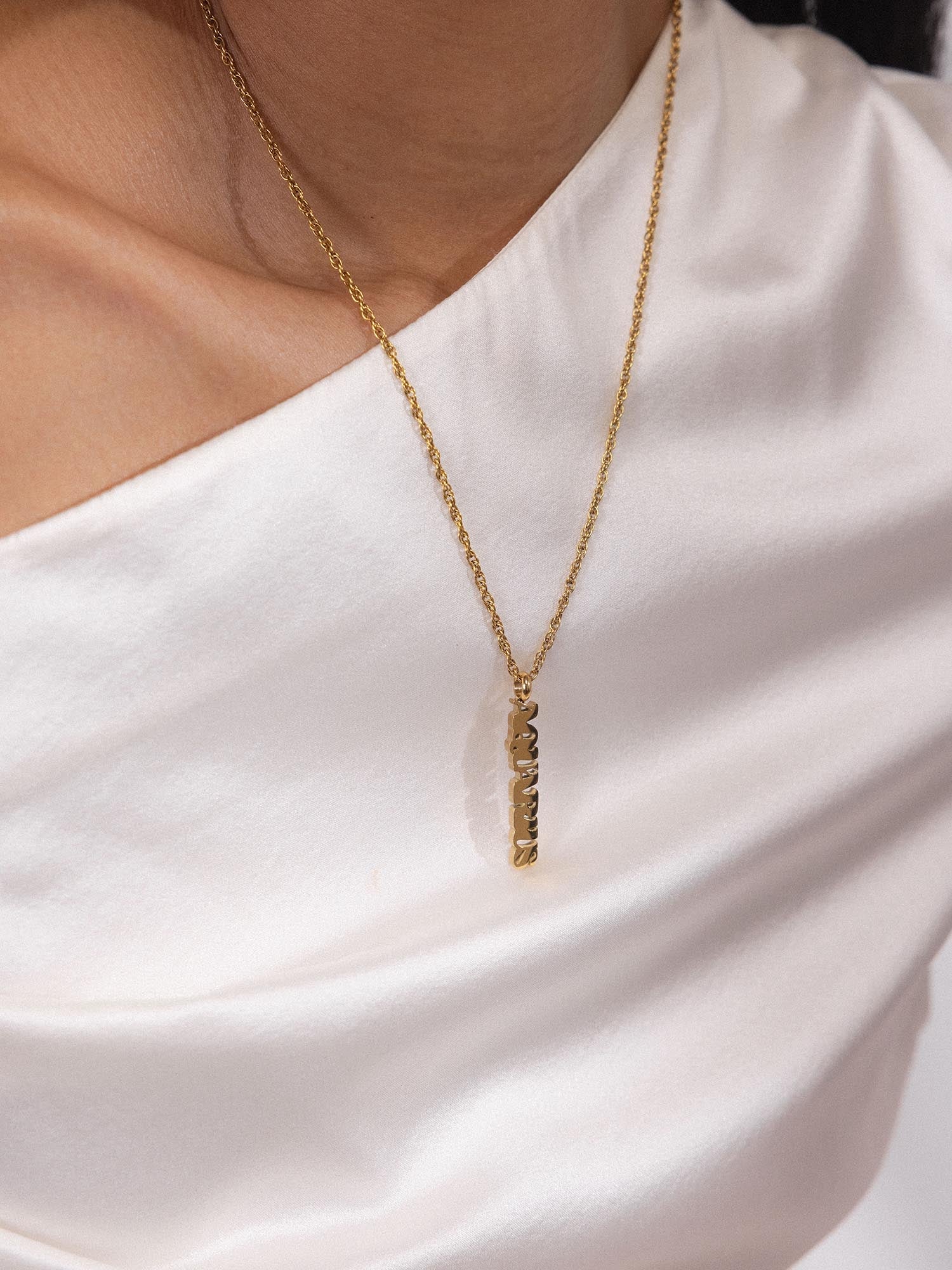 Aquarius Letter Charm aus 18K vergoldetem Edelstahl an zarter Kette, elegant und feminin von PURELEI getragen.