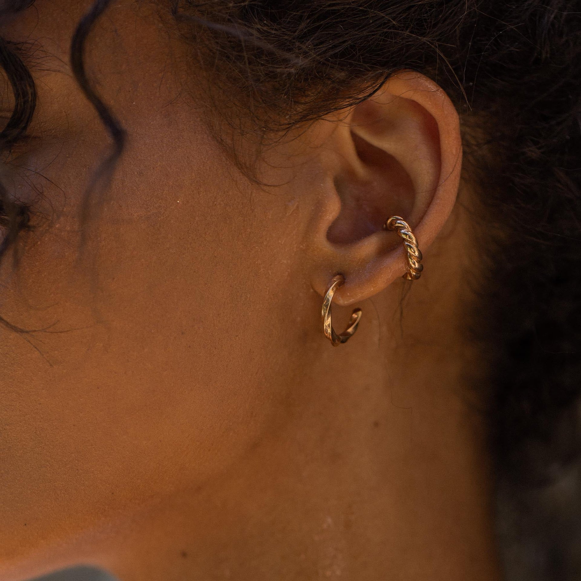 Roségoldene Creolen mit elegantem Design, getragen von PURELEI.