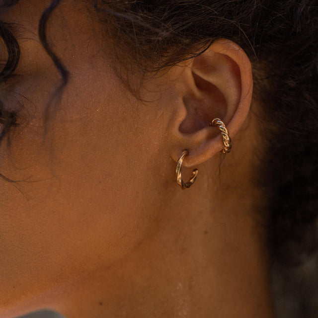 Roségoldene Creolen mit elegantem Design, getragen von PURELEI.