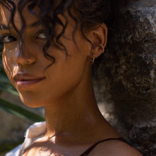 Roségoldene Creolen von PURELEI, elegant und feminin, umrahmen das Gesicht in tropischer Stimmung.