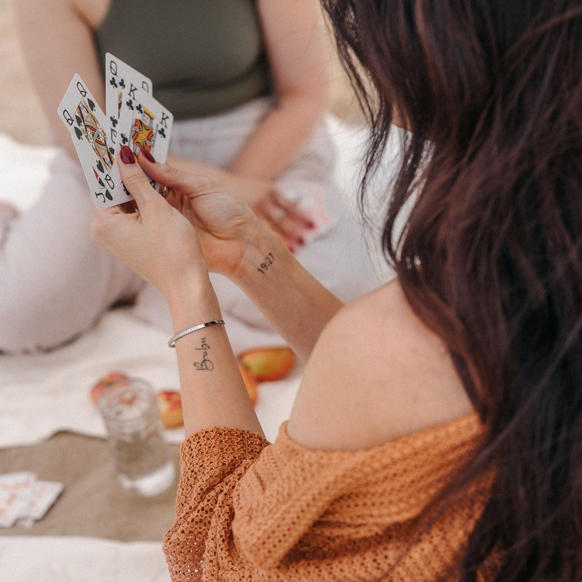 Elegantes Armband von PURELEI, getragen während eines Kartenspiels, in warmen Erdtönen.