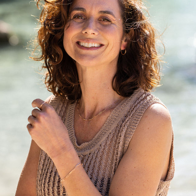 Double Match Anxiety Ring von PURELEI, vergoldet, ineinander verschlungene Ringe, getragen, warmes Sonnenlicht, elegante Leichtigkeit.