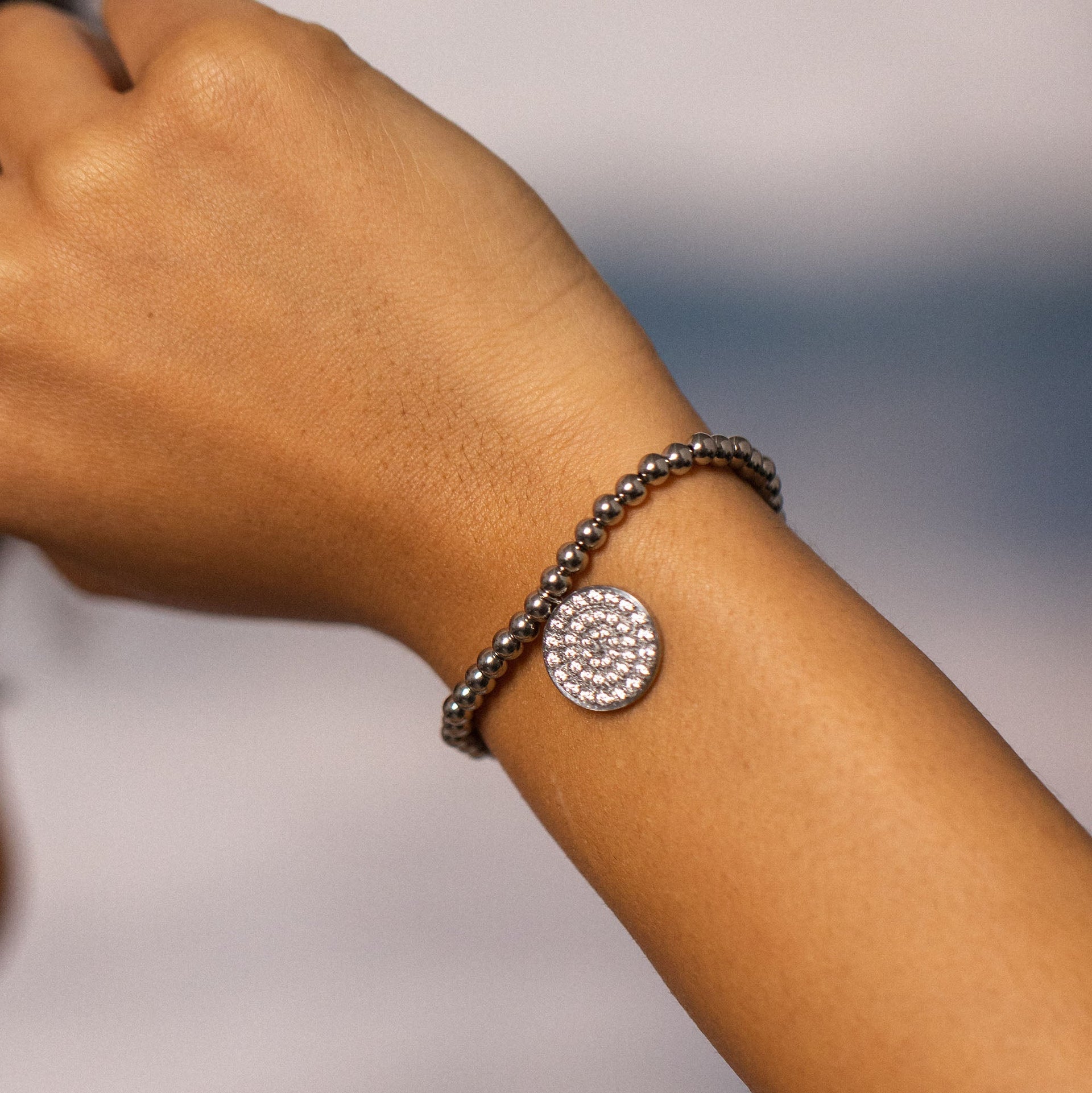 Elegantes Armband mit Kristall-Anhänger, PURELEI, auf braunem Handgelenk.