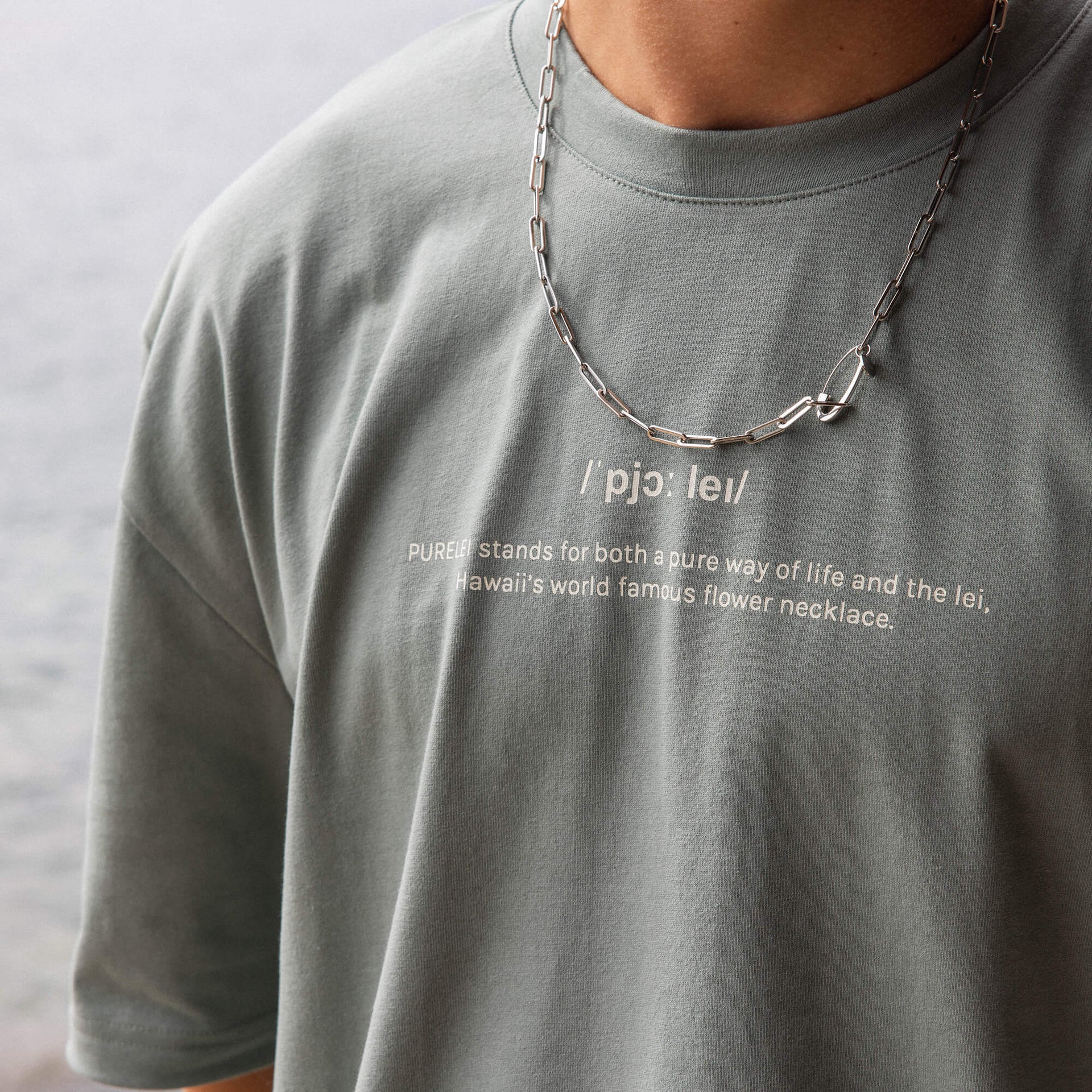 Silberne Kette mit Gliedern, getragen über grauem T-Shirt, PURELEI inspiriert von Aloha-Vibes.