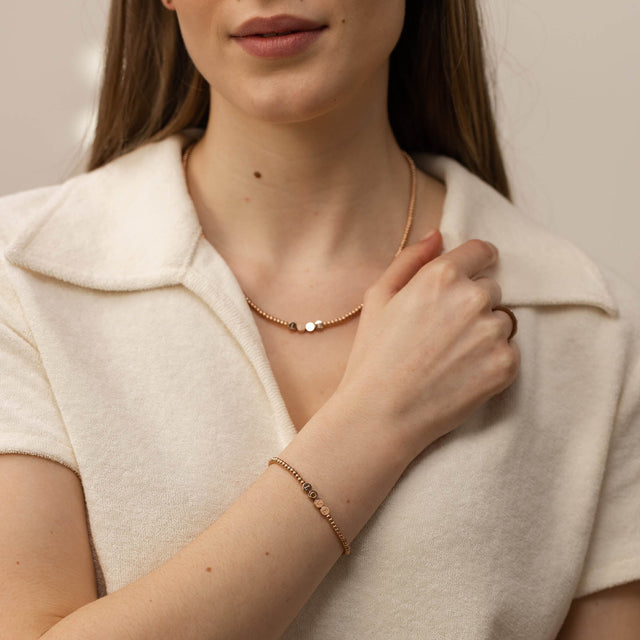 Elegante, roségoldene Kette und Armband von PURELEI, feminin und modern, getragen auf weichem Stoff.