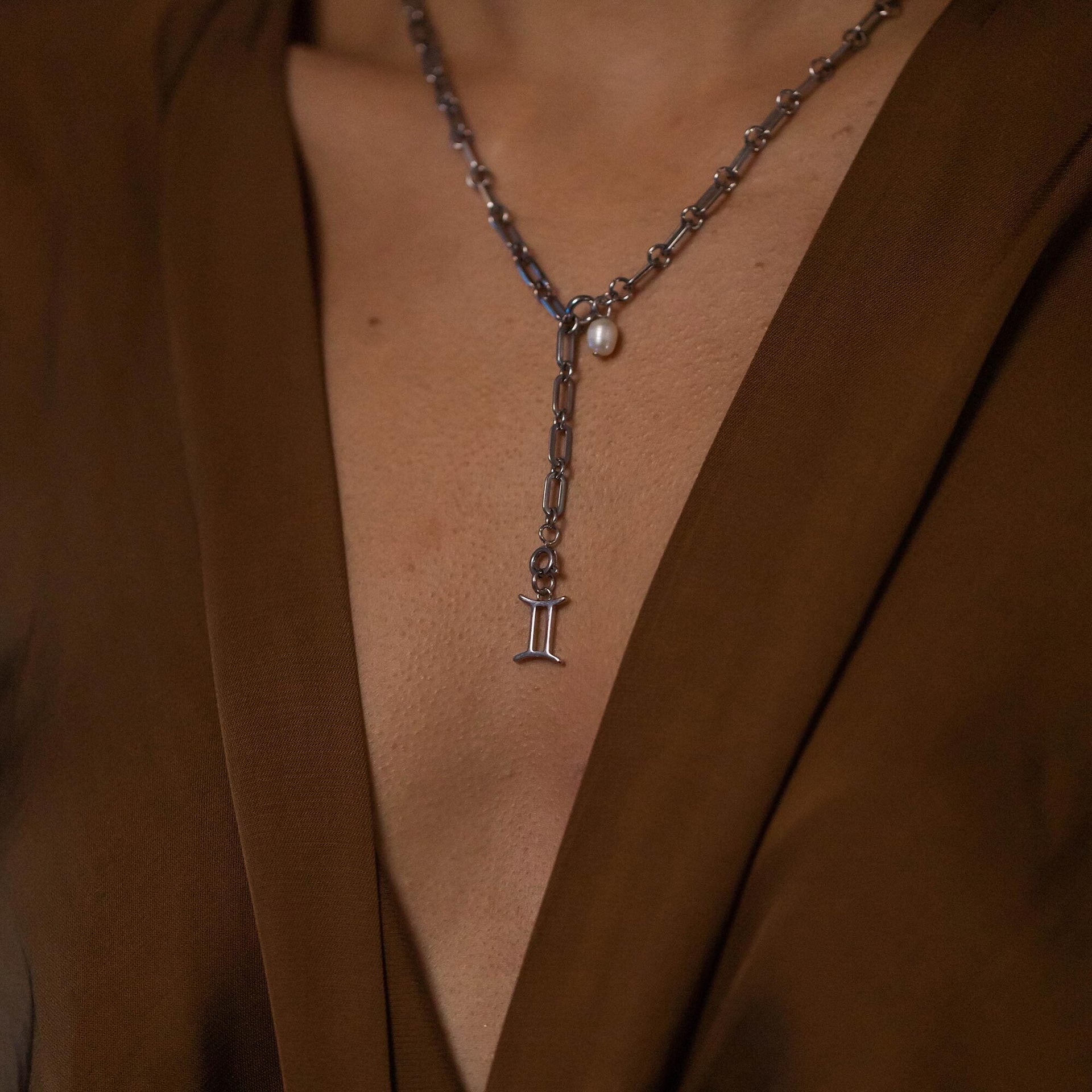 PURELEI Zwilling Zodiac Charm aus nickelfreiem Edelstahl mit feinem Sternzeichen-Anhänger am Dekolleté.