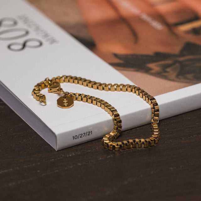 PURELEI Solidarity Armband aus 18K vergoldetem Edelstahl, elegant auf Buch liegend, zeitlos und feminin.