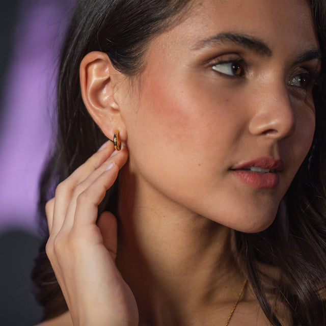 Roségoldene Creolen von PURELEI, elegant und feminin, getragen in sanfter Beleuchtung.