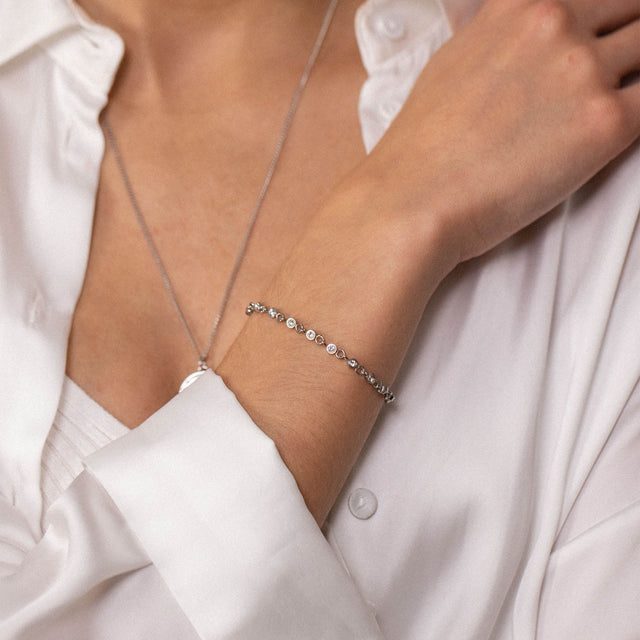 Silbernes Armband mit funkelnden Steinen, elegant am Handgelenk getragen, PURELEI.