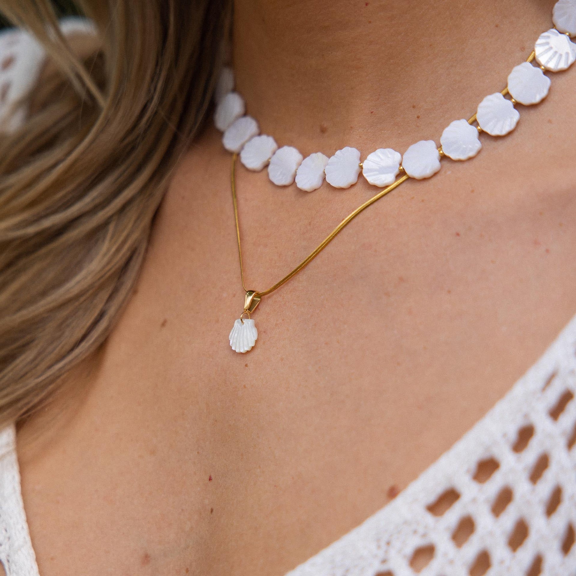 Weißes Muschel-Halsband und goldene Kette mit Muschel-Anhänger von PURELEI, elegant und maritim.