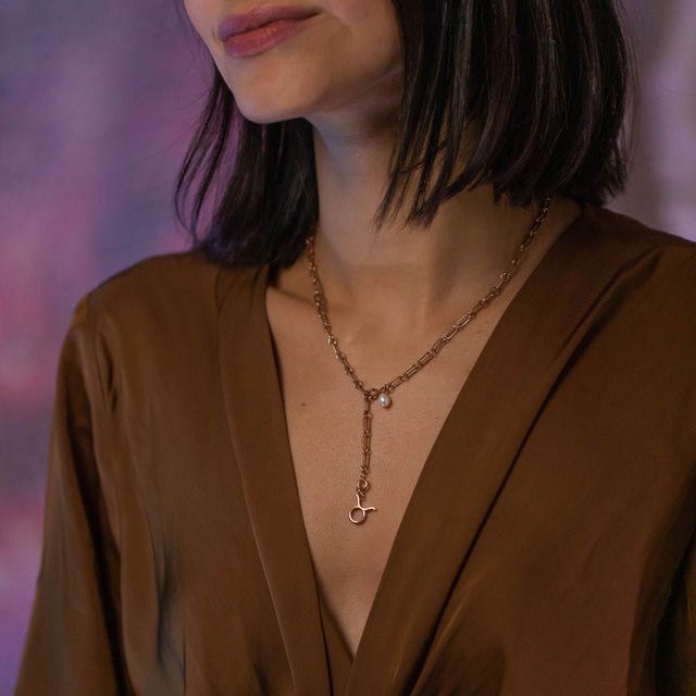 Stier Zodiac Charm in 18K Roségold, filigran am Dekolleté getragen, elegant und feminin von PURELEI.